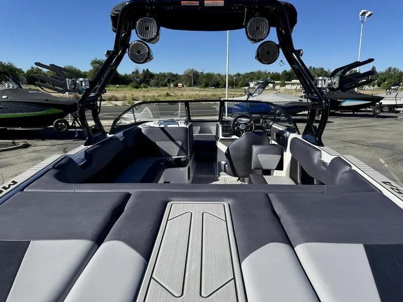 Slide: The Image of 2020 Moomba Max boat interior with seating and speakers, parked outdoors. - 15