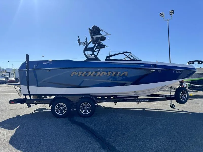 Slide: The Image of 2020 Moomba Max boat on trailer in parking lot, blue and white design. - 3