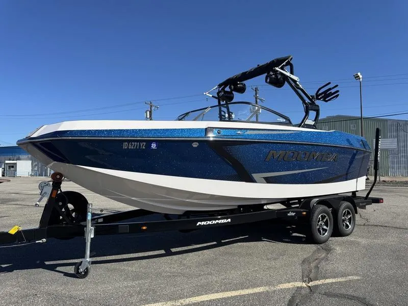Slide: The Image of 2020 Moomba Max boat on trailer, blue and white, parked outdoors under clear sky. - 5