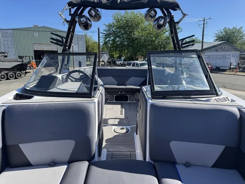 Slide: The Image of 2020 Moomba Max boat interior with open windshield, gray seating, and tower speakers. - 7