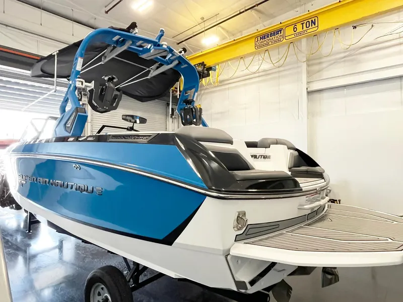 Slide: The Image of 2020 Nautique G21 boat in a garage, featuring a sleek blue and white design. - 3