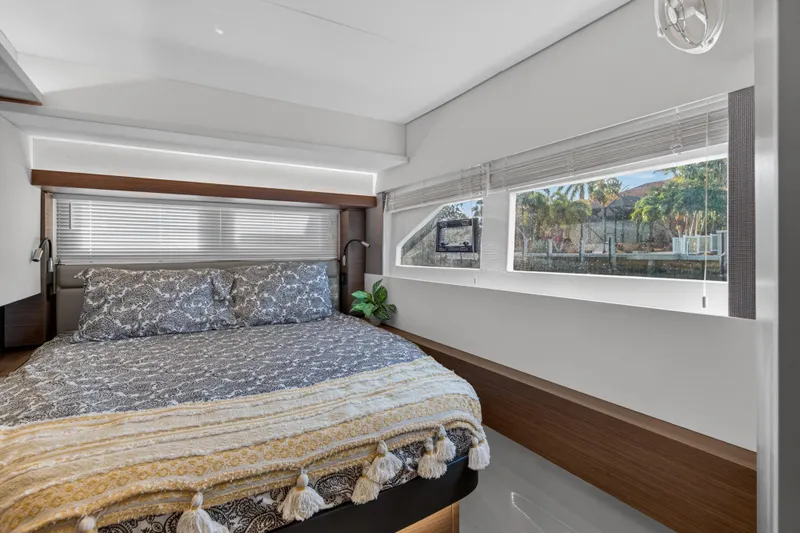Slide: The Image of Luxurious bedroom interior of 2022 Leopard 53 Powercat yacht with large windows and elegant bedding. - 101