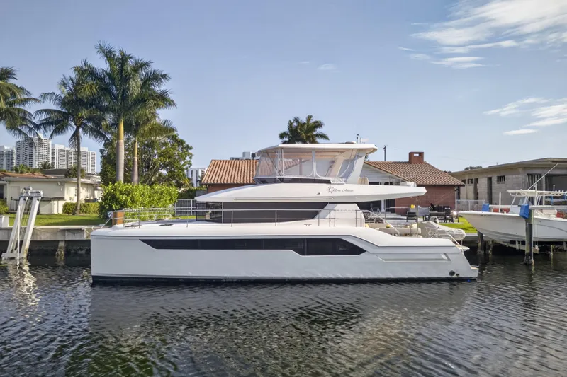 Slide: The Image of 2022 Leopard 53 Powercat yacht docked by palm trees and waterfront homes. - 123