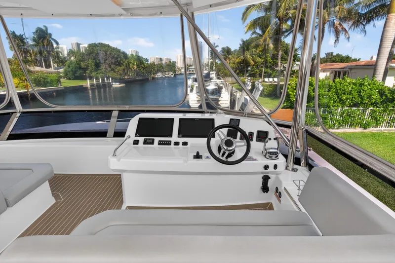 Slide: The Image of Cockpit view of 2022 Leopard 53 Powercat yacht with modern controls and scenic waterfront. - 13