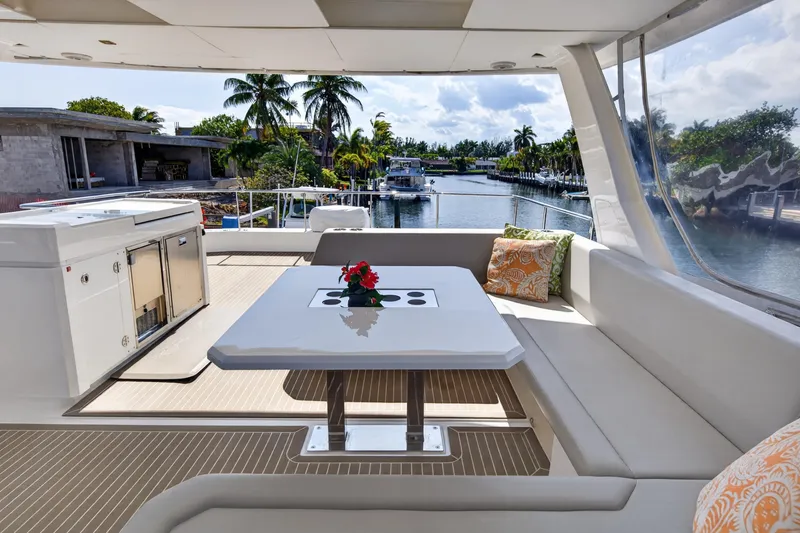 Slide: The Image of Luxurious 2022 Leopard 53 Powercat yacht deck with seating, table, and scenic waterfront view. - 19