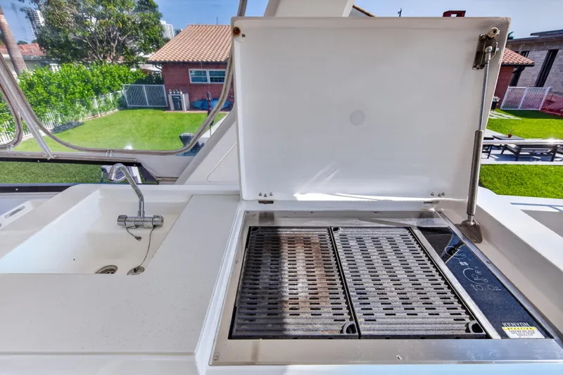 Slide: The Image of Outdoor kitchen on 2022 Leopard 53 Powercat with grill and sink, surrounded by greenery. - 25