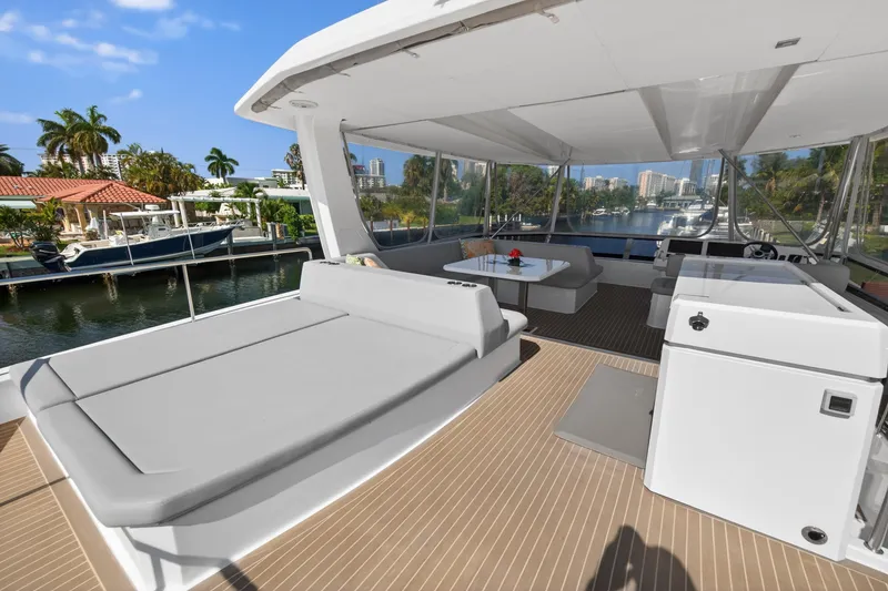 Slide: The Image of Luxurious 2022 Leopard 53 Powercat yacht deck with seating and scenic waterfront view. - 26
