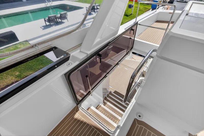 Slide: The Image of Staircase on 2022 Leopard 53 Powercat yacht, overlooking a poolside view. - 28