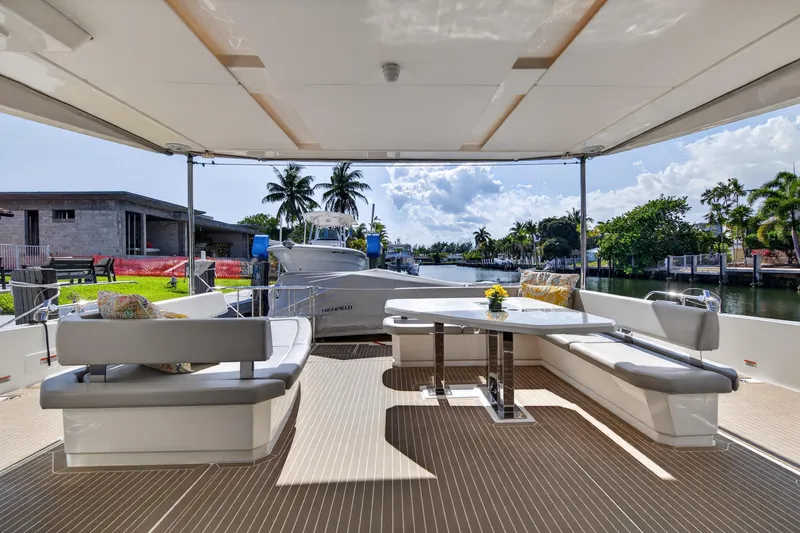 Slide: The Image of Outdoor seating area on a 2022 Leopard 53 Powercat yacht, featuring a table and cushions. - 36