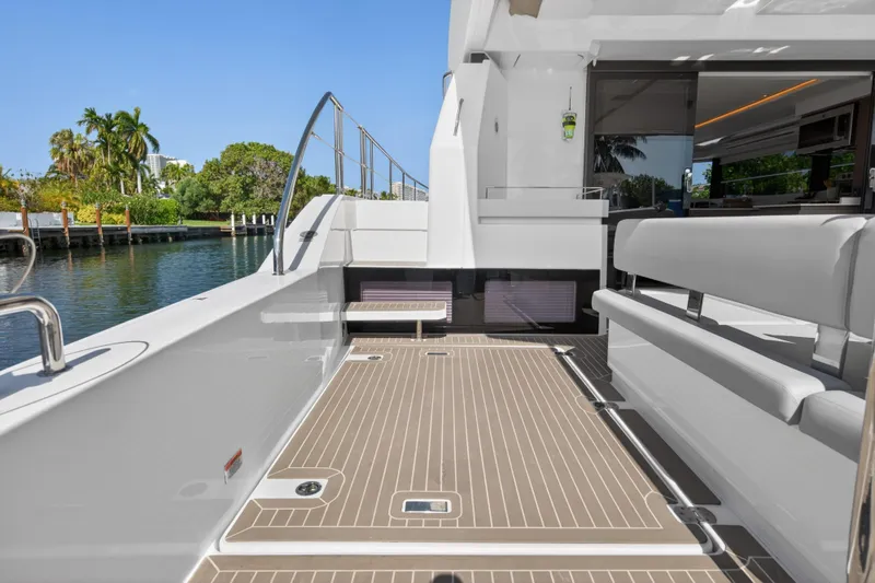 Slide: The Image of 2022 Leopard 53 Powercat yacht deck with seating, docked by lush greenery and calm waters. - 46