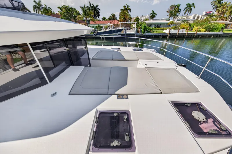 Slide: The Image of Leopard 53 Powercat 2022 yacht deck with sun loungers and waterfront view. - 48