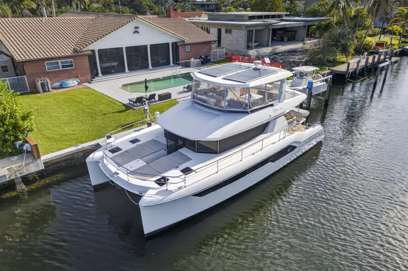 Slide: The Image of 2022 Leopard 53 Powercat yacht docked by a waterfront home with a pool. - 5