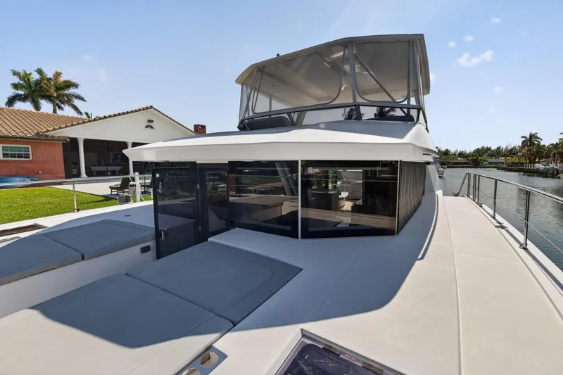 Slide: The Image of 2022 Leopard 53 Powercat yacht docked by waterfront home, showcasing sleek design and spacious deck. - 51