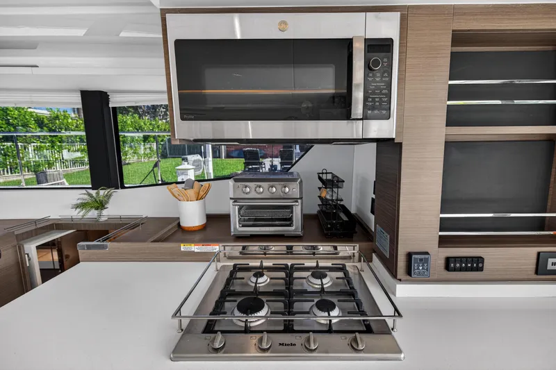 Slide: The Image of Modern kitchen in 2022 Leopard 53 Powercat with stove, microwave, and sleek cabinetry. - 61