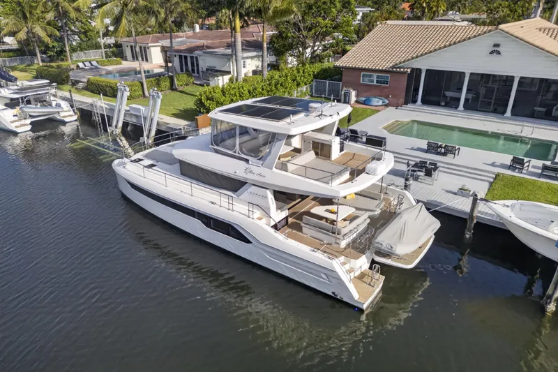 Slide: The Image of 2022 Leopard 53 Powercat yacht docked by a luxurious waterfront home with a pool. - 7