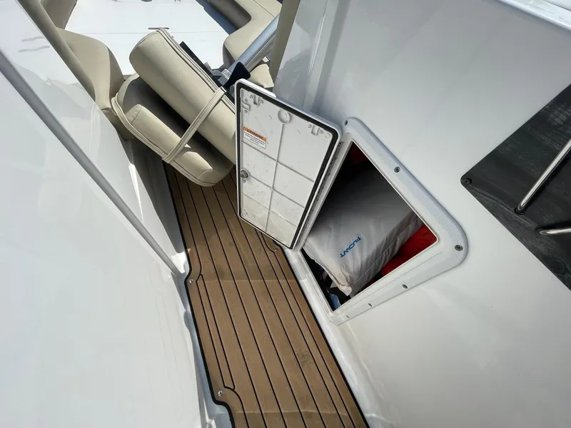 Slide: The Image of Hurricane SD235 boat interior with open storage compartment, cushioned seats, and wooden flooring, 2020 model. - 10