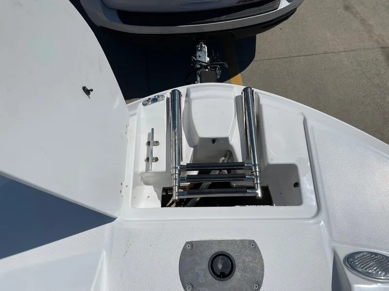 Slide: The Image of 2020 Hurricane SD235 boat with stainless steel ladder and open hatch, parked on a trailer. - 13