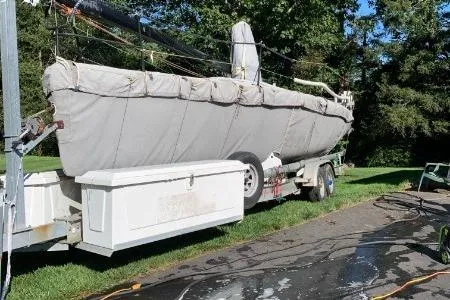 Slide: The Image of Covered 2007 Melges 32 sailboat on trailer, parked on grass with trees in background. - 4