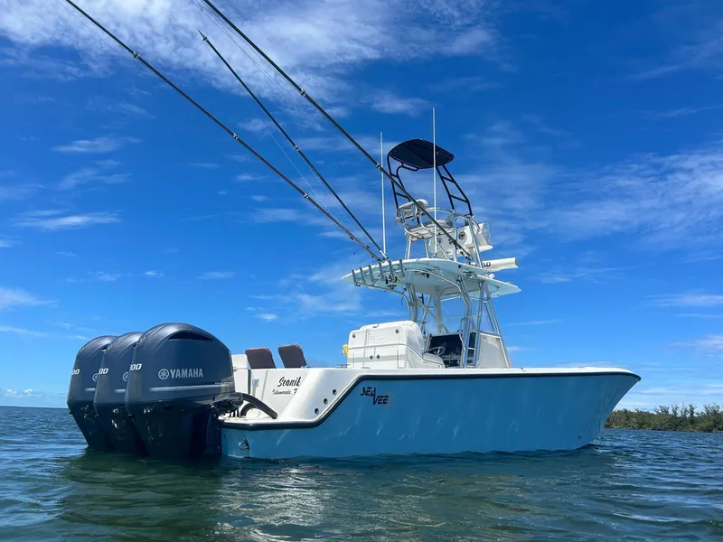 Slide: The Image of 2020 SeaVee 340Z boat with triple Yamaha engines on calm water under blue sky. - 13
