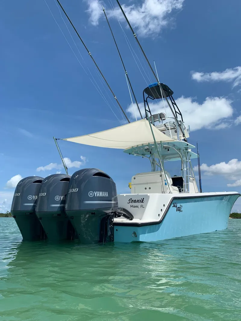 Slide: The Image of 2020 SeaVee 340Z boat with triple Yamaha engines on clear water under blue sky. - 14
