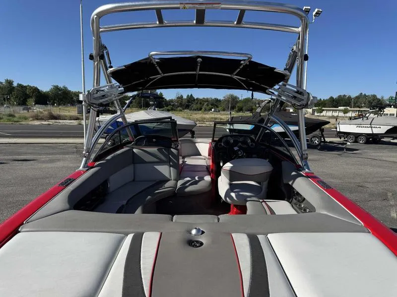 Slide: The Image of 2009 Supra 21V LAUNCH boat interior with seating and steering wheel, parked outdoors. - 11