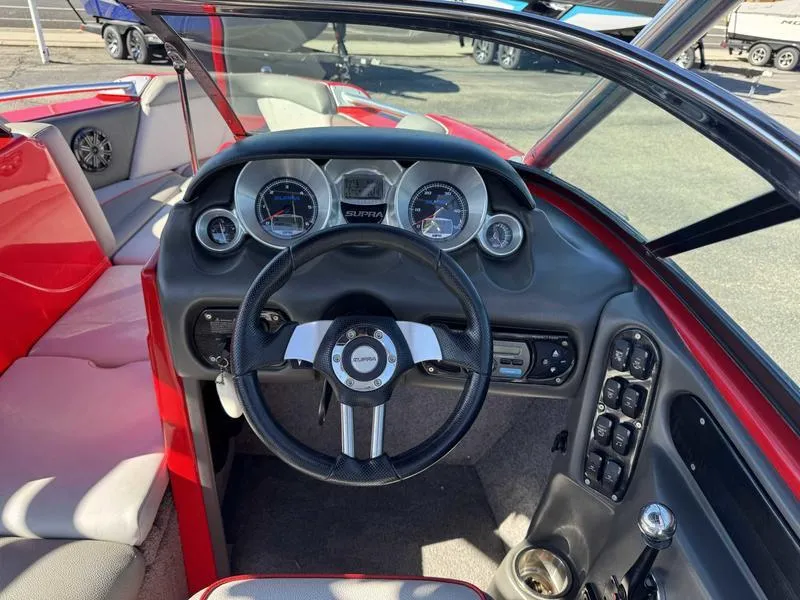 Slide: The Image of 2009 Supra 21V LAUNCH boat dashboard with steering wheel and control panel. - 2
