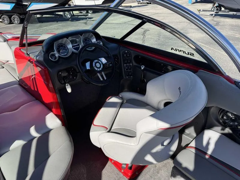 Slide: The Image of 2009 Supra 21V LAUNCH boat interior with red and gray seating, steering wheel, and dashboard. - 4