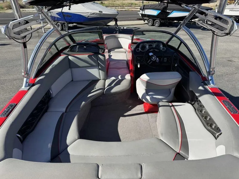 Slide: The Image of 2009 Supra 21V LAUNCH boat interior with gray and red seating, steering console, and cup holders. - 6