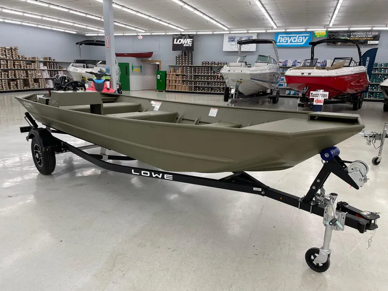 Slide: The Image of 2025 Lowe Jon L1852MT boat on display in a showroom with other boats. - 5