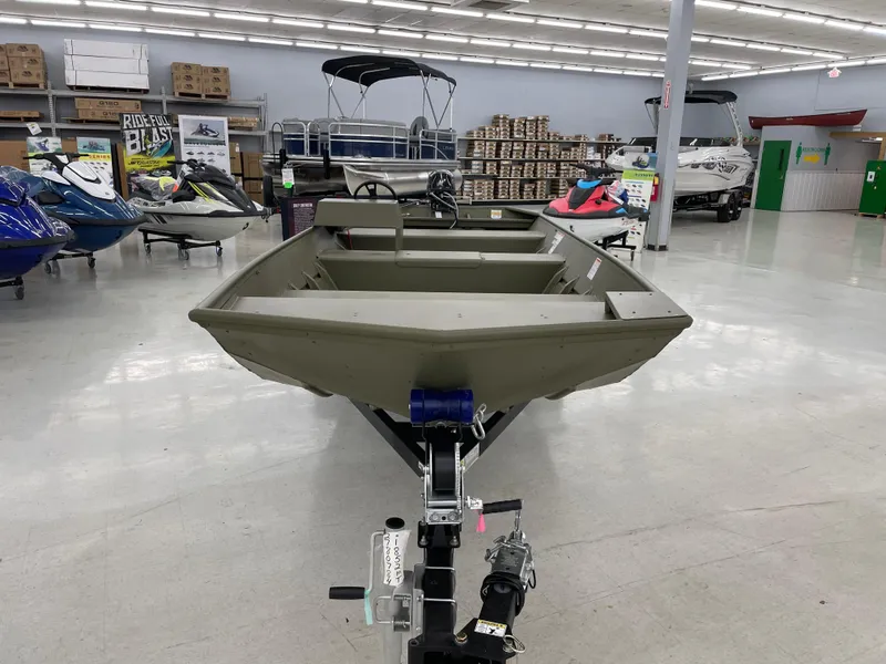 Slide: The Image of 2025 Lowe Jon L1852MT boat displayed in showroom with various watercraft. - 6