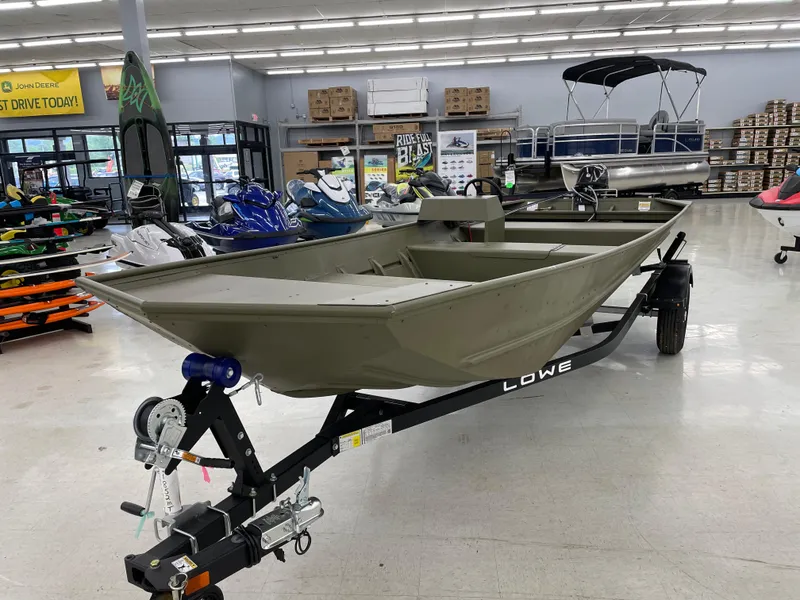 Slide: The Image of 2025 Lowe Jon L1852MT boat on display in a showroom with various watercraft. - 7