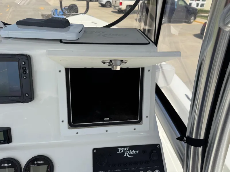 Slide: The Image of 2020 Bay Rider 239 Bay boat console with open storage compartment and navigation equipment. - 17