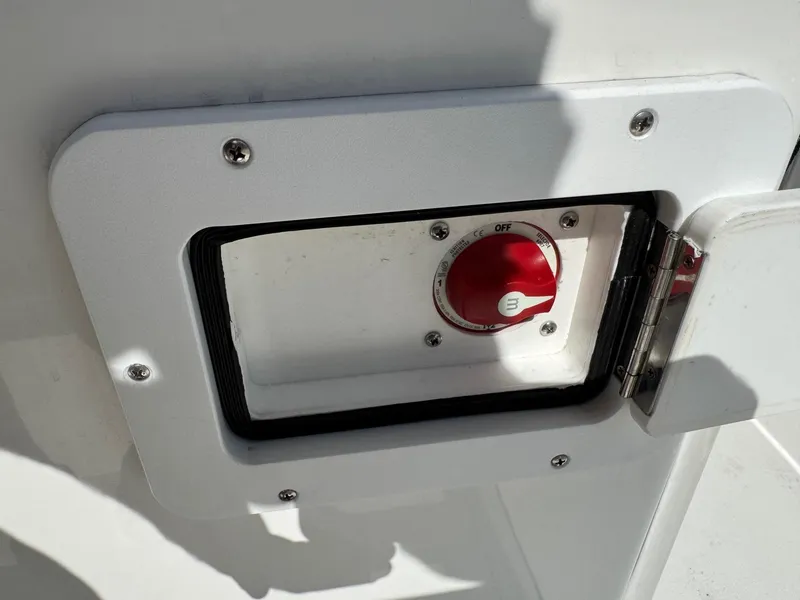 Slide: The Image of Bay Rider 239 Bay 2020 boat battery switch compartment with red knob and open hatch. - 18