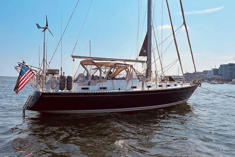 Slide: The Image of Sailing yacht Stevens 40, 1983 model, anchored in a harbor with cityscape background. - 1