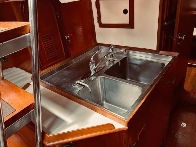 Slide: The Image of 1983 Stevens 40 yacht kitchen with dual stainless steel sinks and wooden cabinetry. - 17