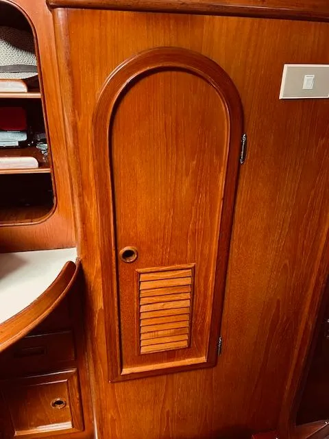 Slide: The Image of Wooden interior of a 1983 Stevens 40 yacht, featuring a curved door and shelving. - 23