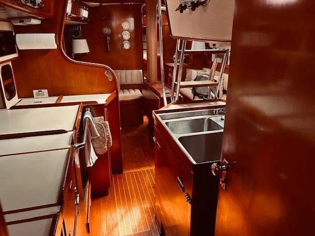 Slide: The Image of Interior of a 1983 Stevens 40 yacht with wooden finishes and a compact kitchen area. - 27