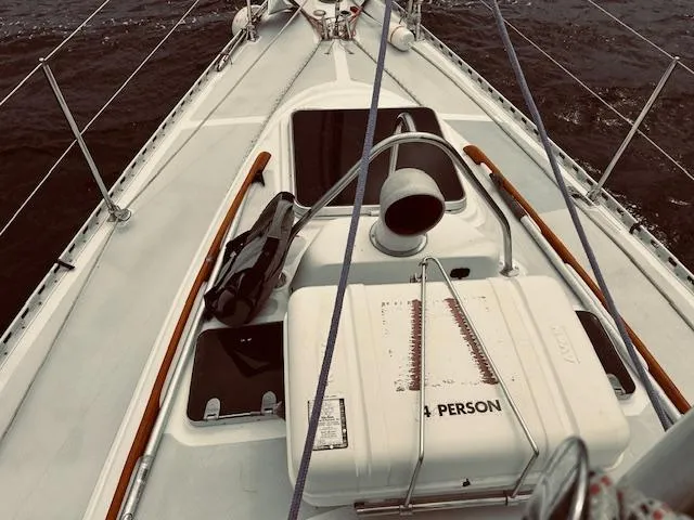 Slide: The Image of 1983 Stevens 40 sailboat deck with life raft and ropes on a calm sea. - 29