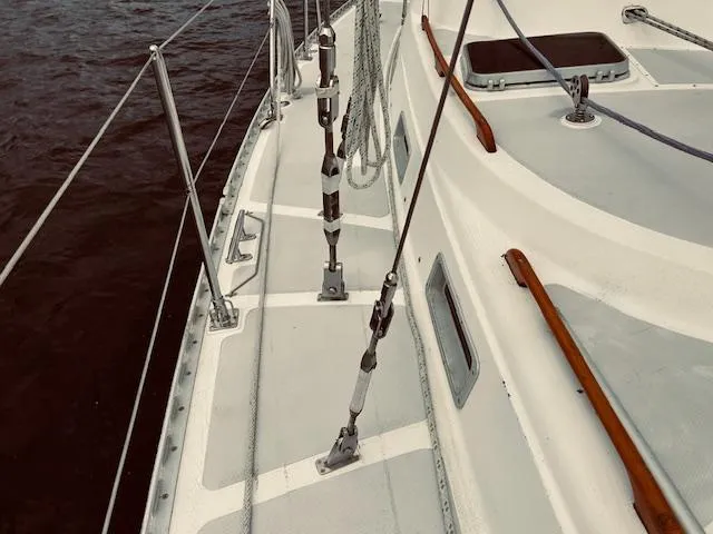 Slide: The Image of 1983 Stevens 40 sailboat deck with rigging and wooden accents on a calm sea. - 30