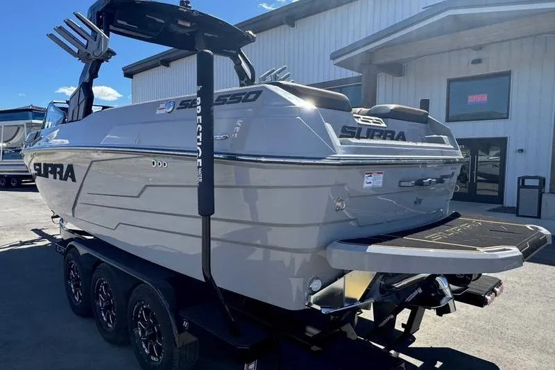 Slide: The Image of 2025 Supra SE boat on trailer, parked outside a building under clear skies. - 10