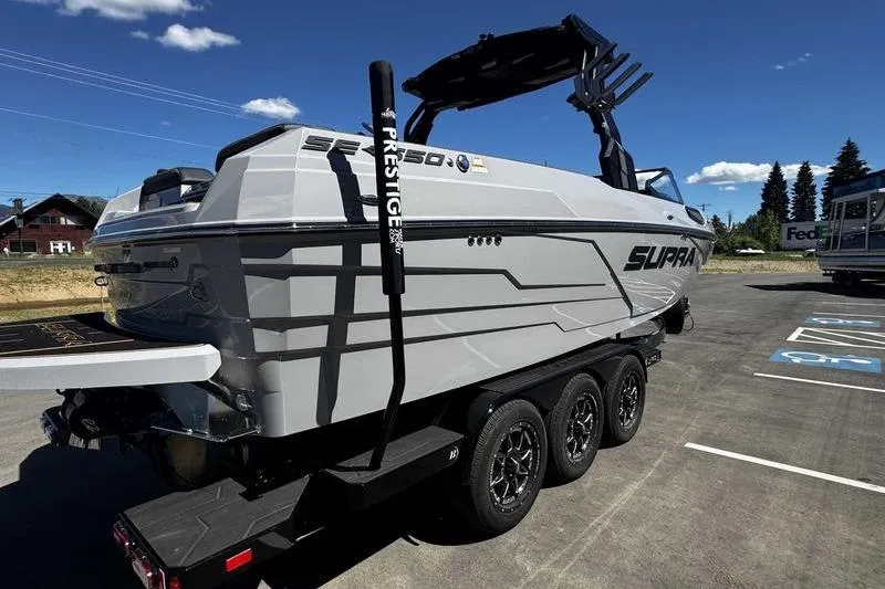 Slide: The Image of 2025 Supra SE boat on trailer, sleek design, parked outdoors under clear sky. - 11
