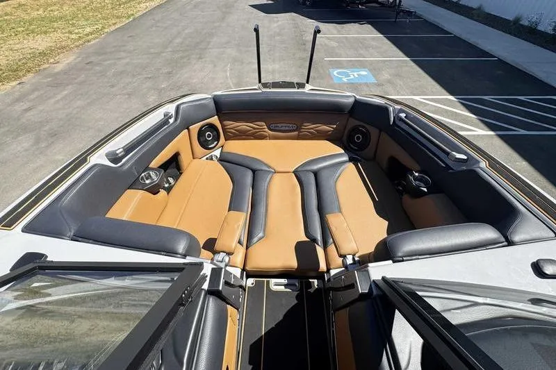 Slide: The Image of 2025 Supra SE boat interior with tan and black seating, parked on asphalt. - 19