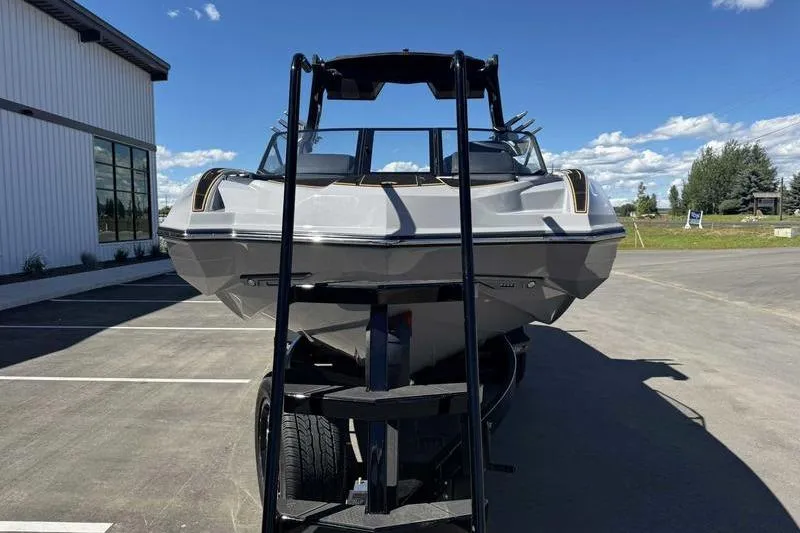 Slide: The Image of 2025 Supra SE boat on trailer, parked outdoors under a clear blue sky. - 4