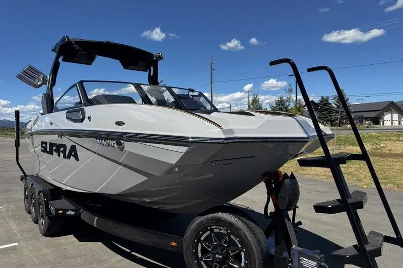 Slide: The Image of 2025 Supra SE boat on trailer under clear blue sky. - 7