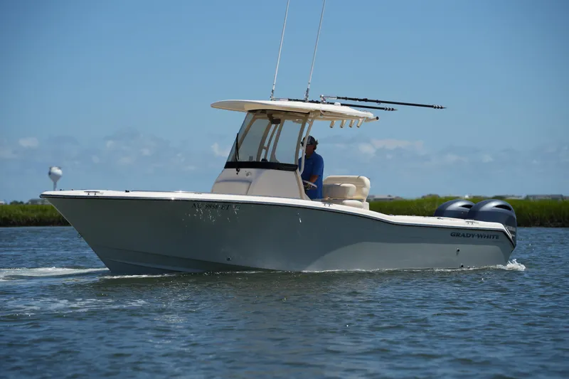 Slide: The Image of 2022 Grady-White Fisherman 257 boat cruising on water under clear blue sky. - 2