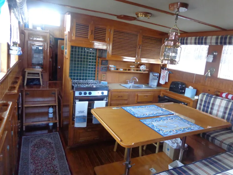 Slide: The Image of 1984 Sundowner Tug Pilothouse interior with wooden flooring and storage compartments. - 12