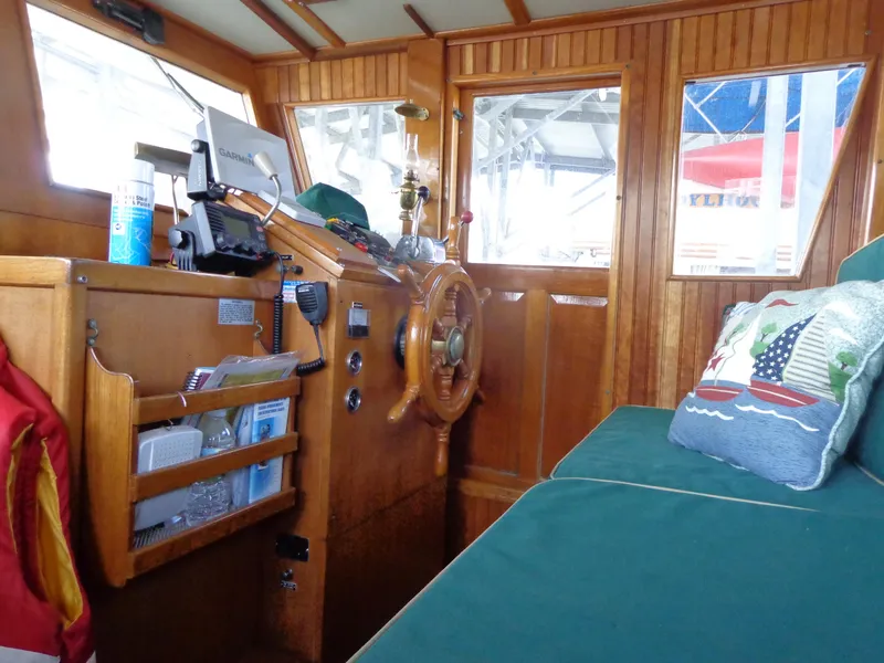 Slide: The Image of 1984 Sundowner Tug Pilothouse interior with plaid seating and wooden dining table. - 17