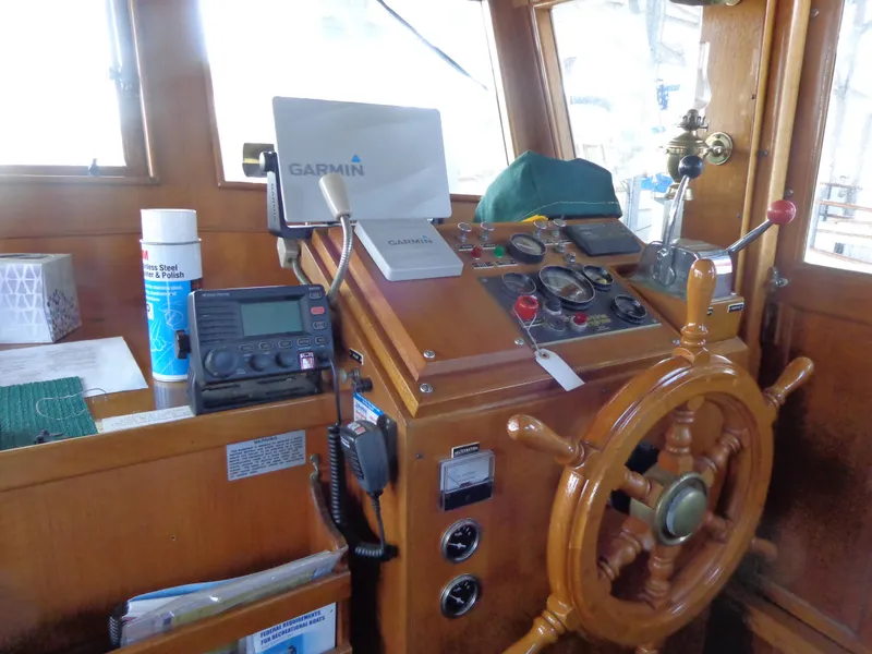 Slide: The Image of 1984 Sundowner Tug Pilothouse interior with wooden finish and navigation equipment. - 21