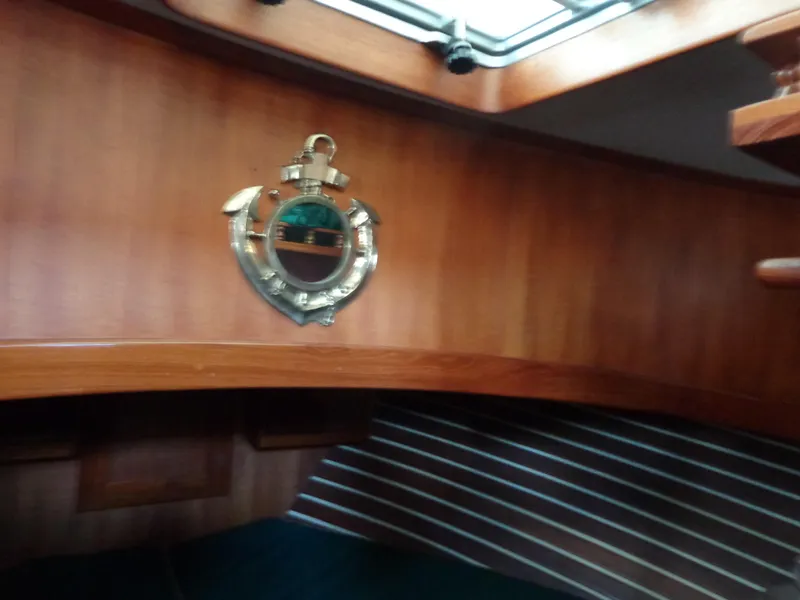 Slide: The Image of 1984 Sundowner Tug Pilothouse interior cabin with green cushions and wooden paneling. - 25