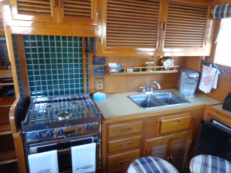 Slide: The Image of 1984 Sundowner Tug Pilothouse interior with plaid seating and dining area. - 37